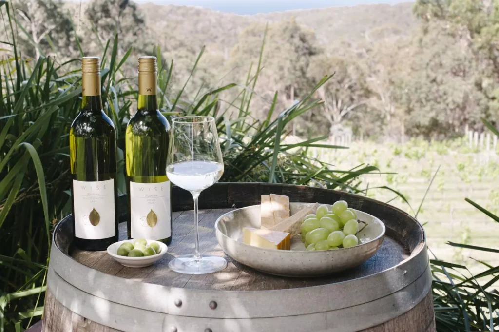 Two bottles of Wise Wine white wine on a barrell